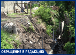 В Крымске мужчине строит забор посреди водоотводного канала