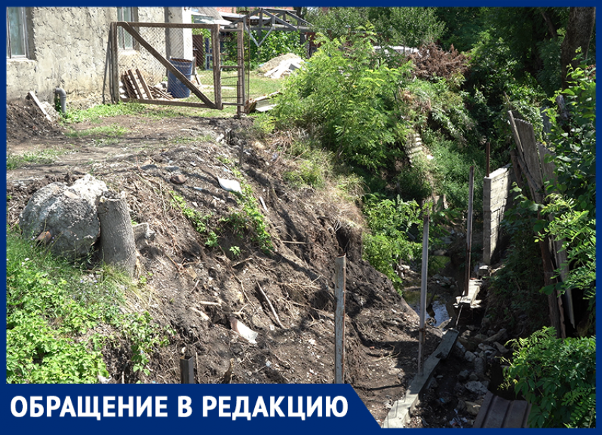 В Крымске мужчине строит забор посреди водоотводного канала